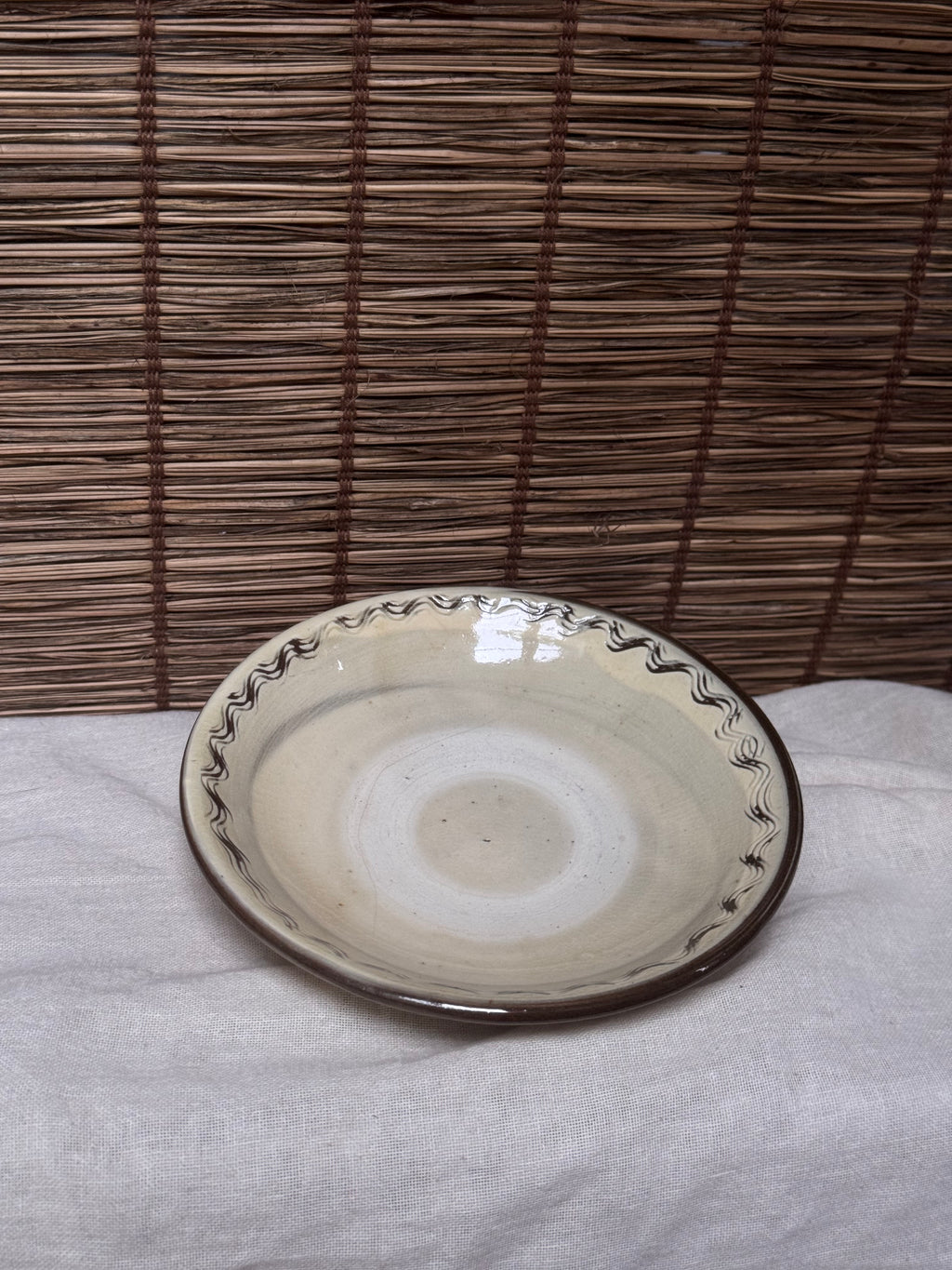 Onta Yaki Shallow Plate — Wavy Brushwork Rim, Ash-Cream Glaze, Wide Unglazed Footring
