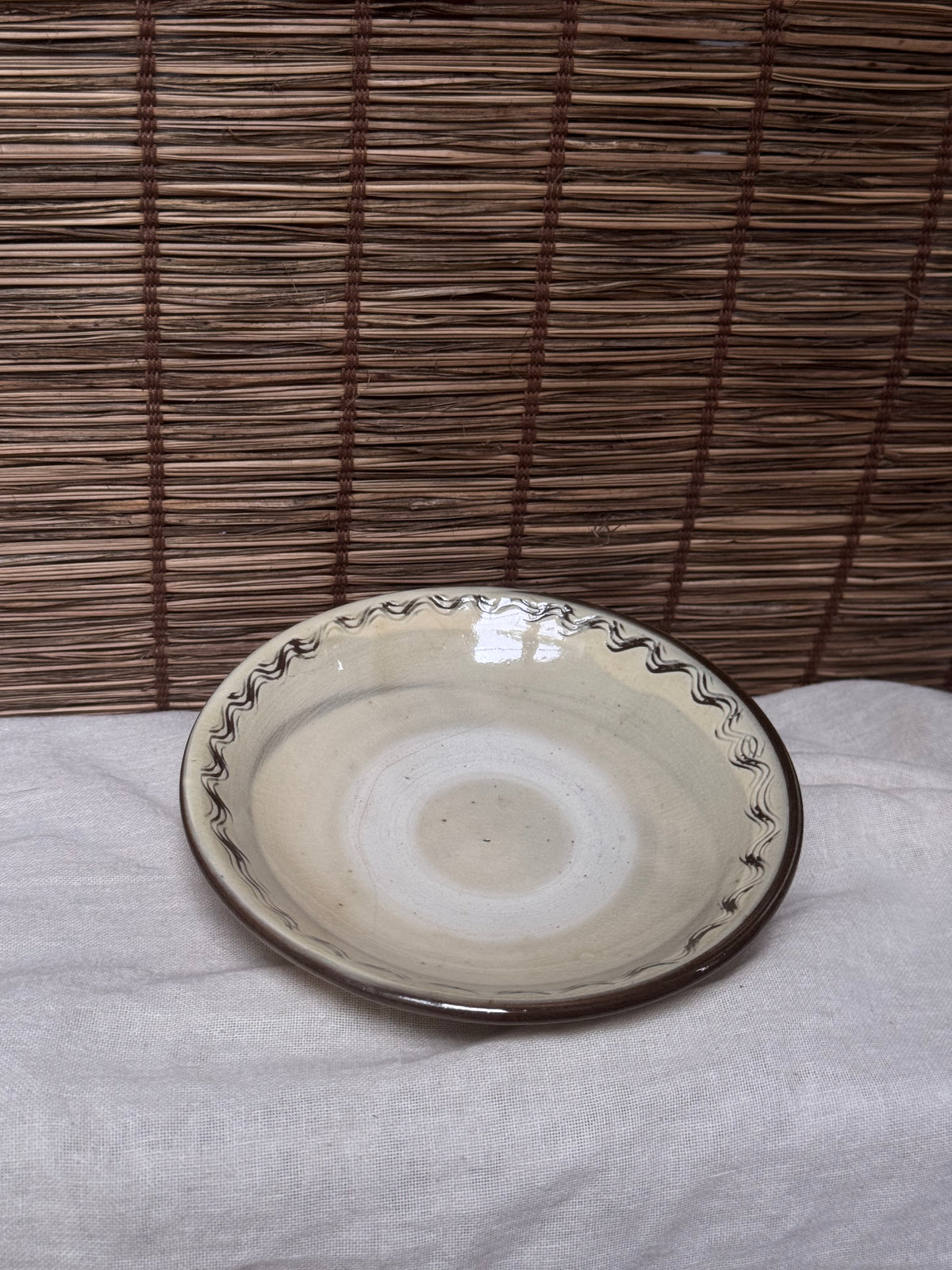 Onta Yaki Shallow Plate — Wavy Brushwork Rim, Ash-Cream Glaze, Wide Unglazed Footring
