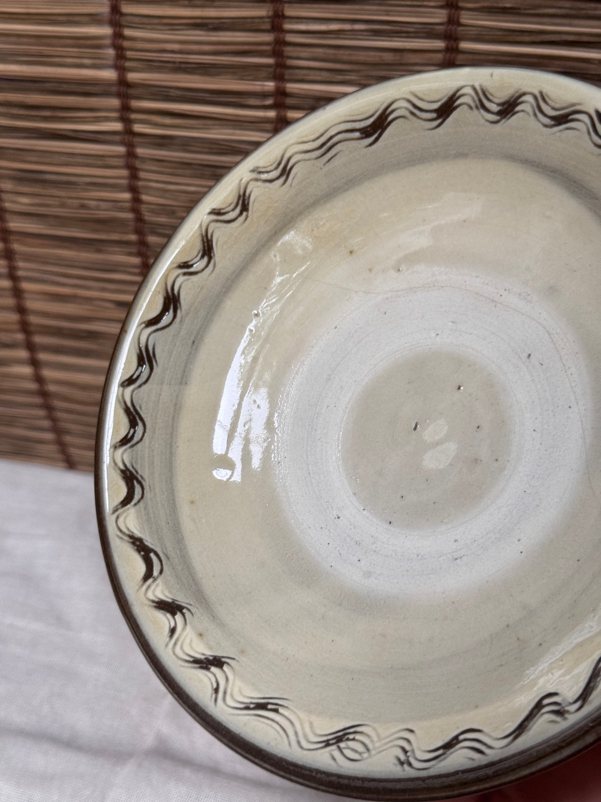 Onta Yaki Shallow Plate — Wavy Brushwork Rim, Ash-Cream Glaze, Wide Unglazed Footring